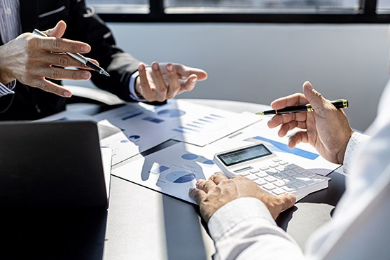 Meeting room atmosphere, business people meeting together on fin Business professionals discussing venture financing with charts and calculator on table during a meeting in a bright office environment